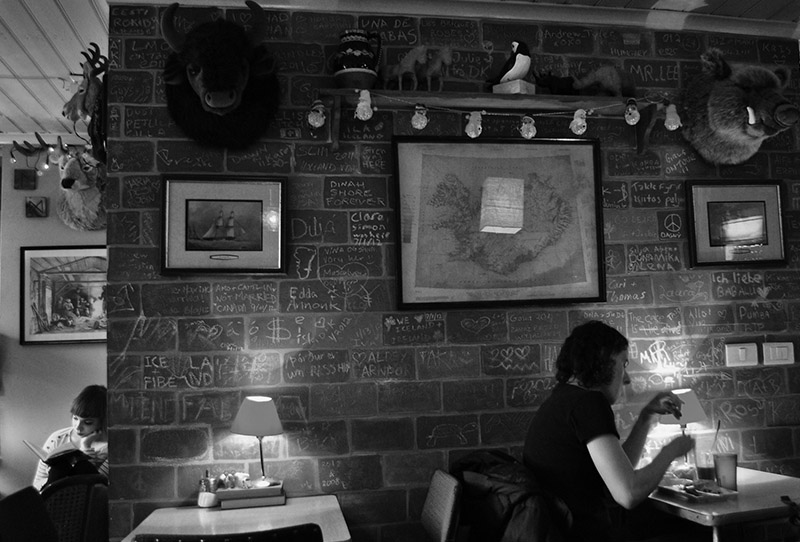 B&W A man enjoyes his drink in a trendy coffee house